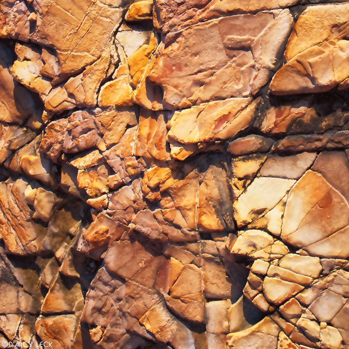 Cracking tan and orange rock face