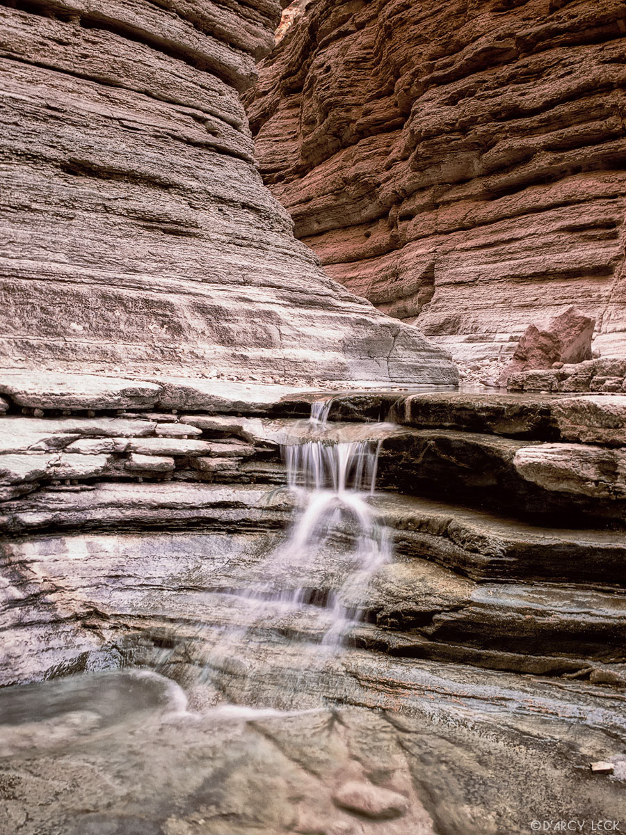 Water falls down slot canyon, Matkatamiba Canyon, Grand Canyon National Park, Arizona