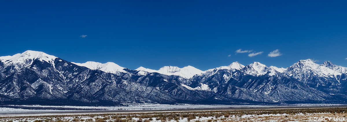 Snow-capped Sangre de Cristo Mountains rise beyond the snow covered plains of the San Luis Valley, Colorado