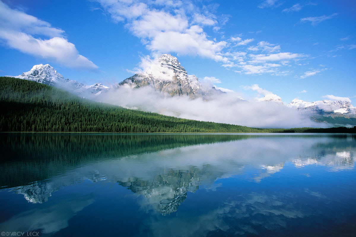 Clouds clear from Howse Peak and Mount Chephren and are reflected in Lower Waterfowl Lake, Banff National Park, Canada