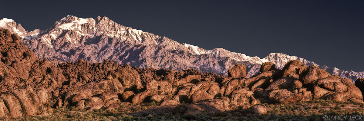 Sunrise light on Mount Williamson and Sierra Nevada Mountains with rock formations of Alabama Hills, California