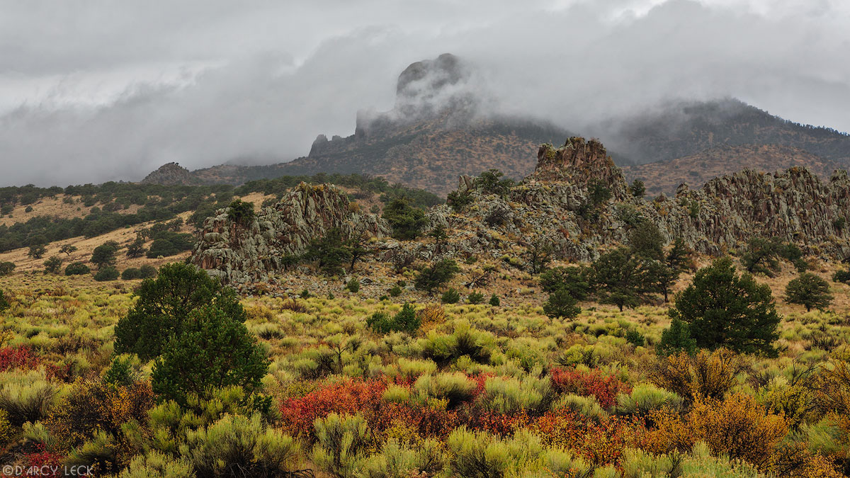Autumn storm clouds enshroud Eagle Mountain beyond high desert range vegetation in autumn colors, Rio Grande National Forest, Colorado