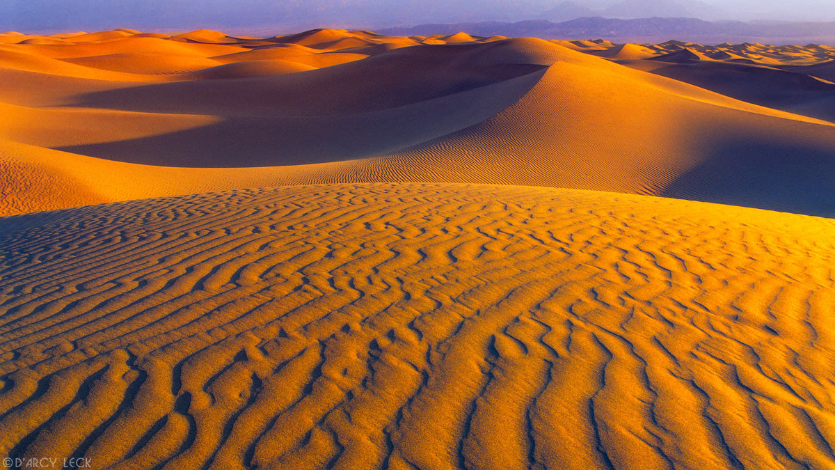 Wind rippled sand textures the sand dunes with Panamint mountains in distance, California