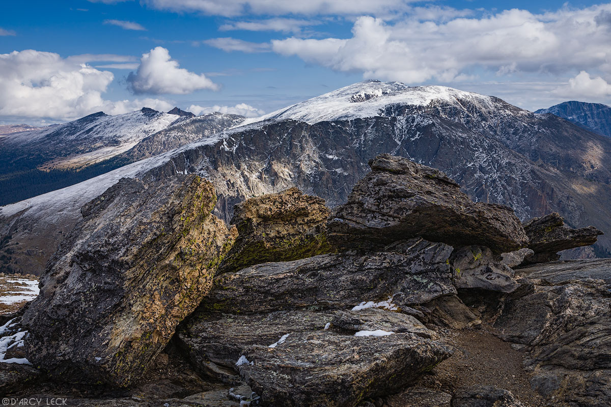 Rock pile on Trail Ridge with snow covered Mummy Range mountains in distance, Colorado