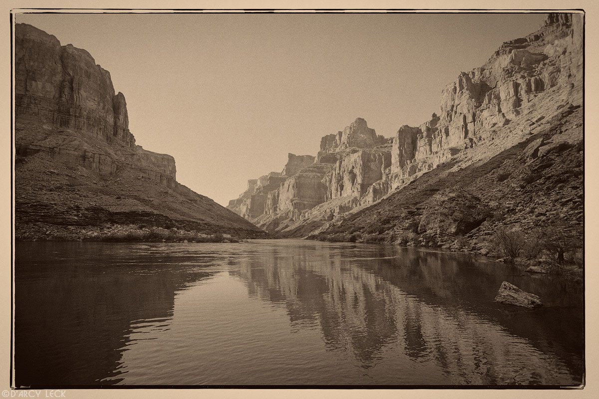 morning sunlight illuminates the walls of Marble Canyon as they are reflected in the Colorado River, Arizona