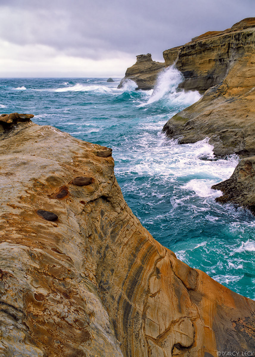 Pacific Ocean waves crashing against cliffs at Cape Kiwanda on Oregon coast