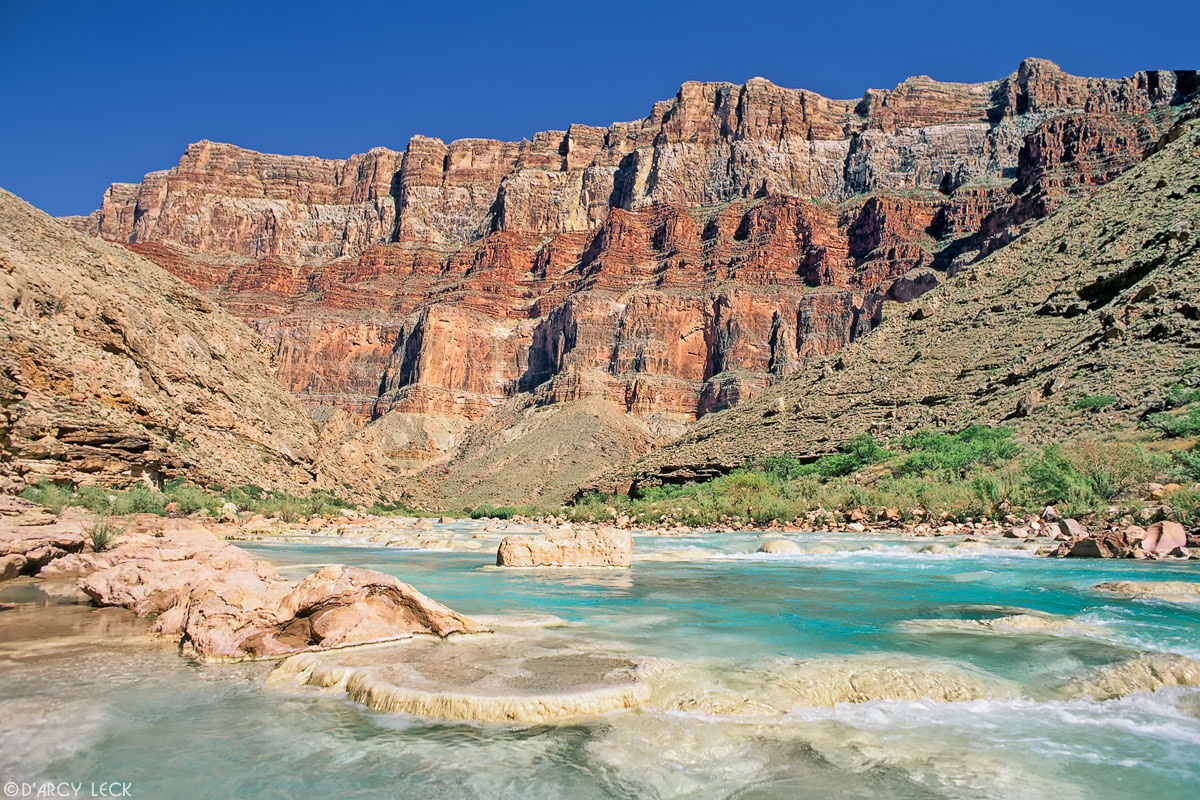 Aquamarine waters of the Little Colorado River flow over travertines towards its confluence with the Colorado River in Marble Canyon, Arizona