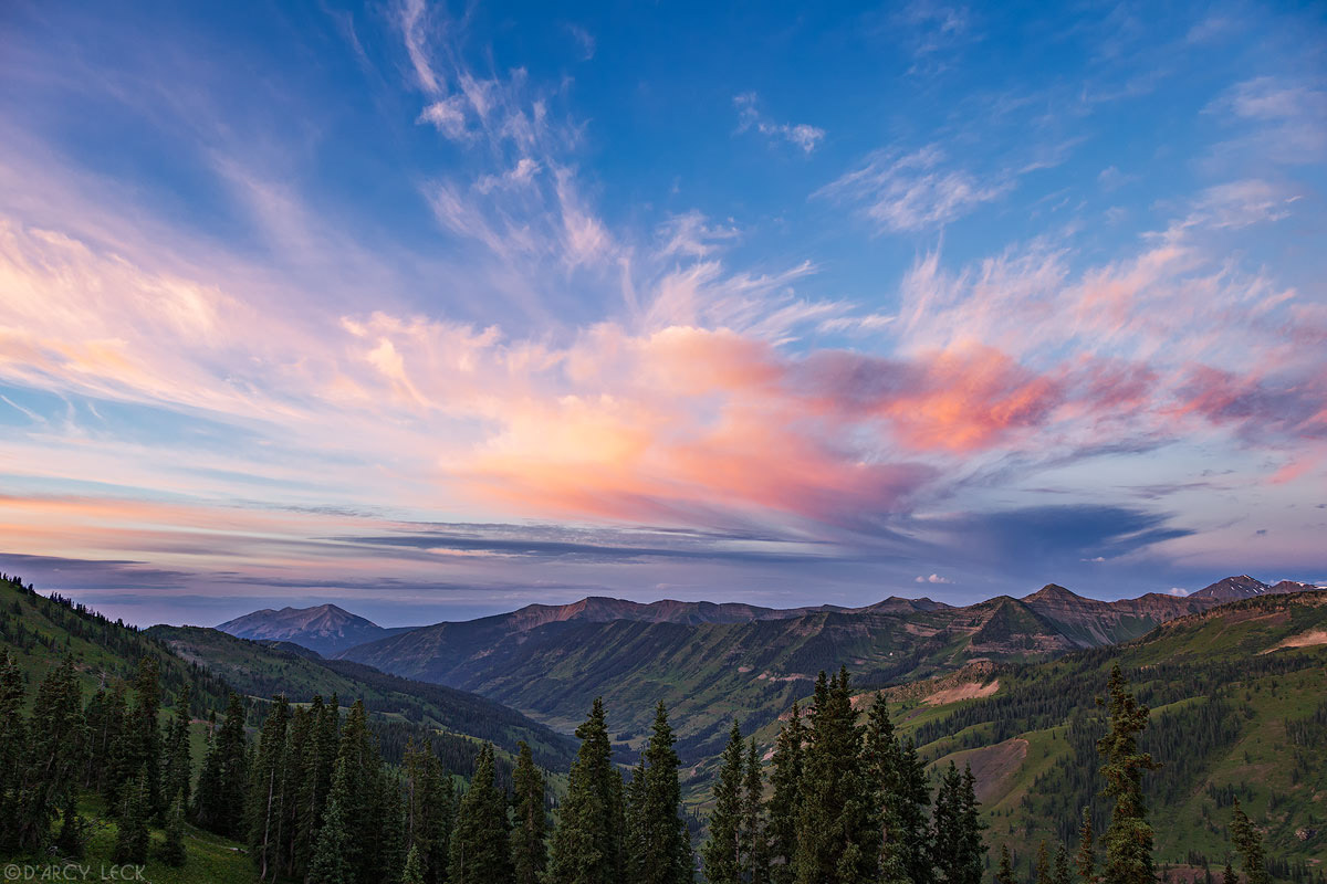 Sunrise colors clouds above the Slate River Valley and Ruby Range mountains as seen from Paradise Divide, Colorado