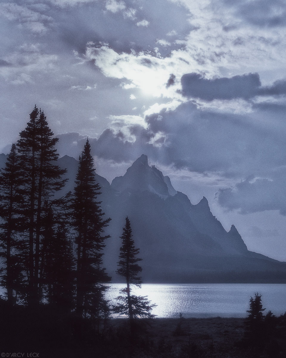 Sunrays beam from behind clouds above The Ramparts and Amethyst Lake, Jasper National Park, Canada