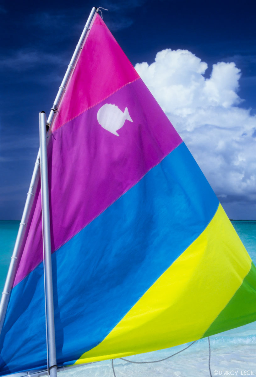 Colorful sail of a Sunfish sailboat, Treasure Cay, Bahamas