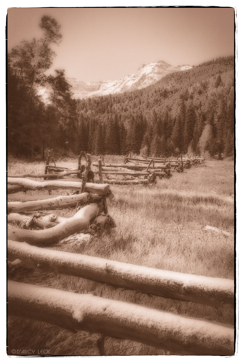 Rail fence with early Autumn snow in field with snow-capped peaks of the San Juan Mountains beyond, Colorado