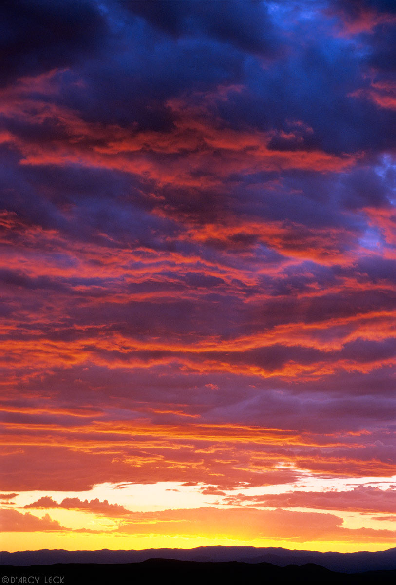 Sunset illuminates clouds over Jemez mountains and central Rio Grande Valley, New Mexico, USA
