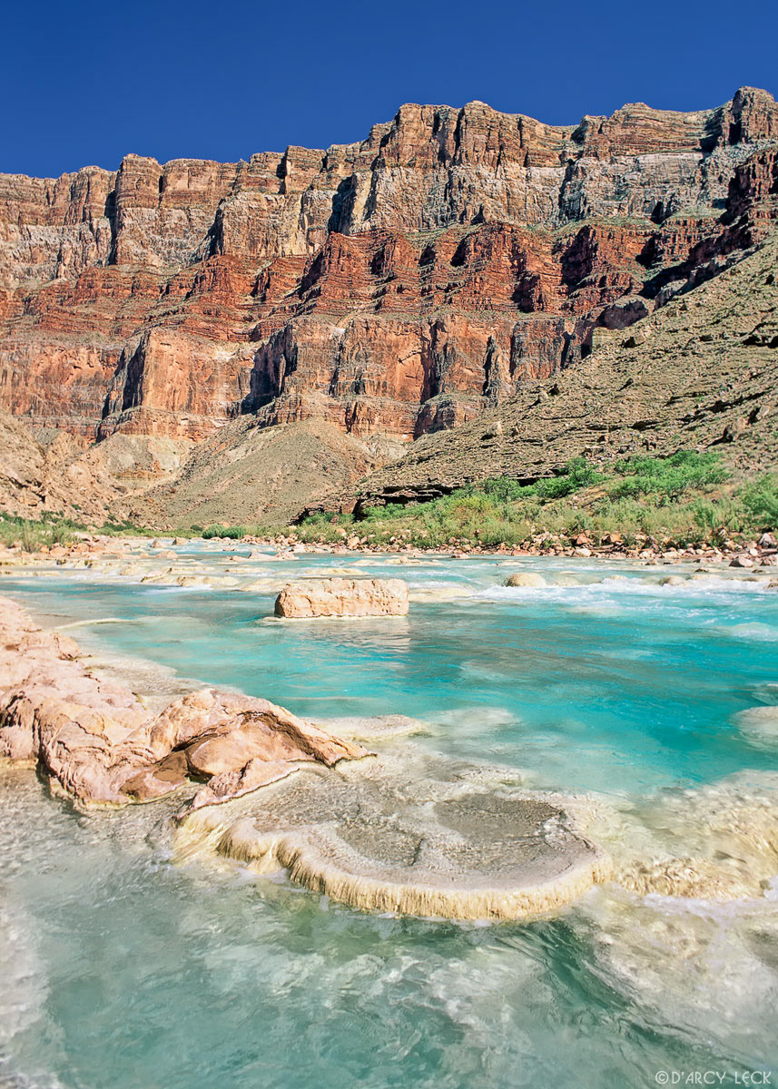 Aquamarine waters of the Little Colorado River flow over travertines towards its confluence with the Colorado River in Marble Canyon, Arizona