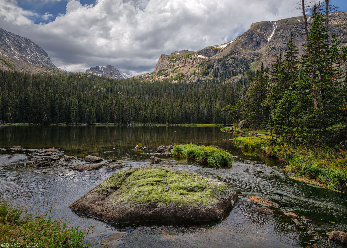 Ouzel Creek flows past rocks out of Ouzel Lake with Ouzel Peak and Isolation Peak in distance, Colorado