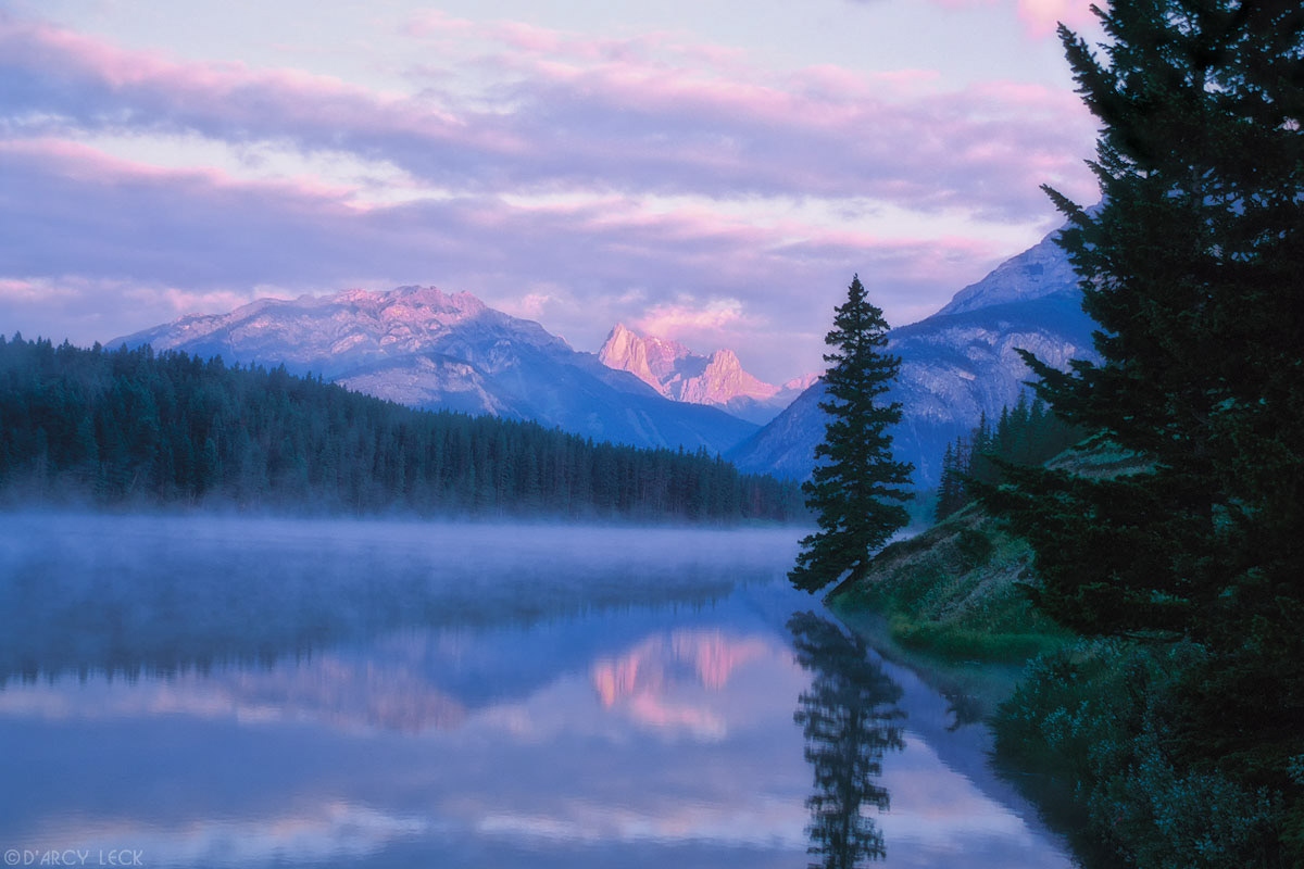Mountains reflect in Johnson Lake at sunrise, Banff National Park, Canada