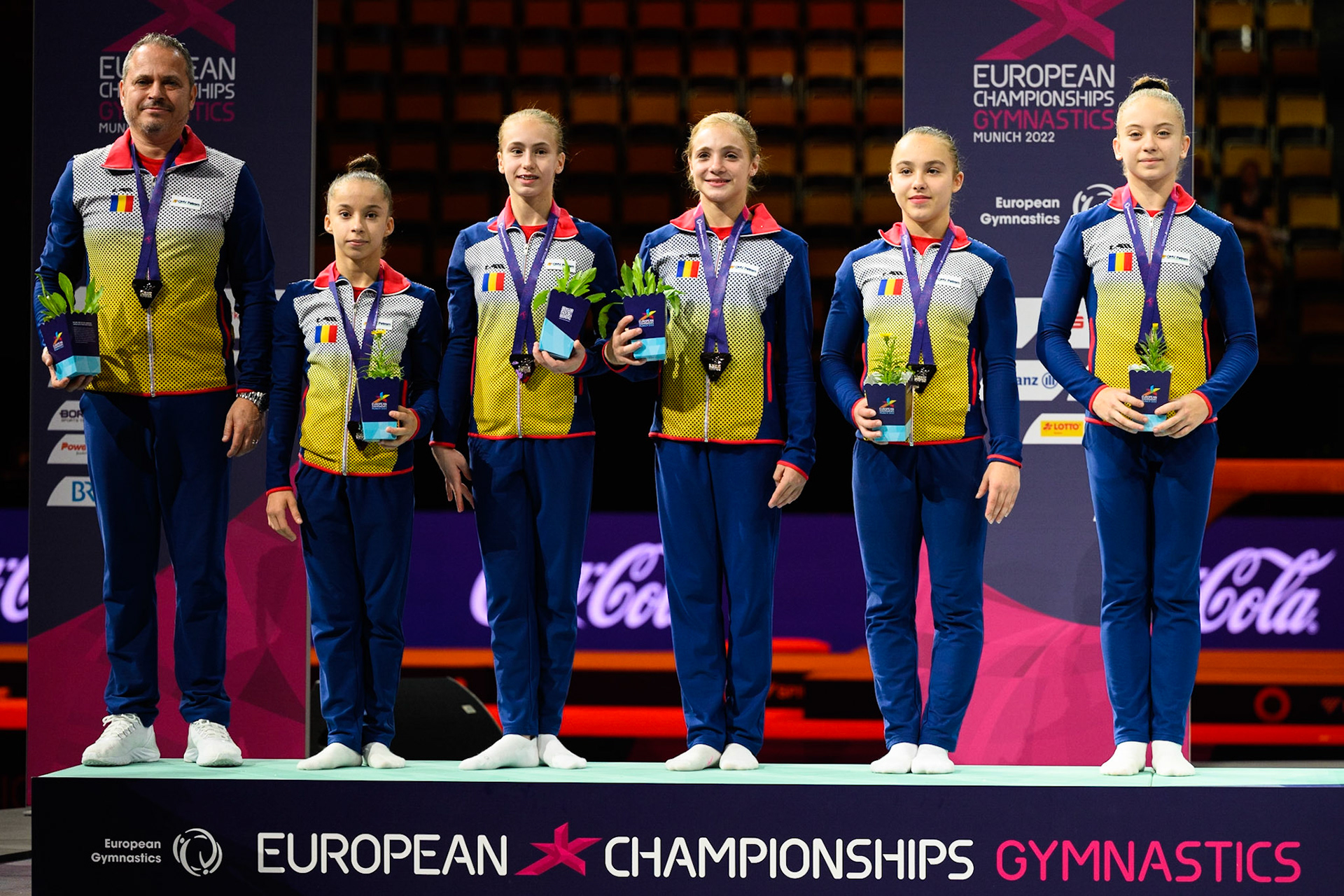 European Championships 2022, Teams Competition, Victory CeremonyDepicted: Amaila Ghigoarta, Amalia Puflea, Crina Tudor, Miruna Botez, Sabrina Maneca-VoineaPhoto taken in Munich, DEU on 2022-08-12Photo credits should read: Norman Seibert, CC BY-SA 4.0NIKON Z 9, NIKKOR Z 70-200mm f/2.8 VR S¹⁄₃₂₀ Sek. bei ƒ / 2,8File: DSC_9353.NEF