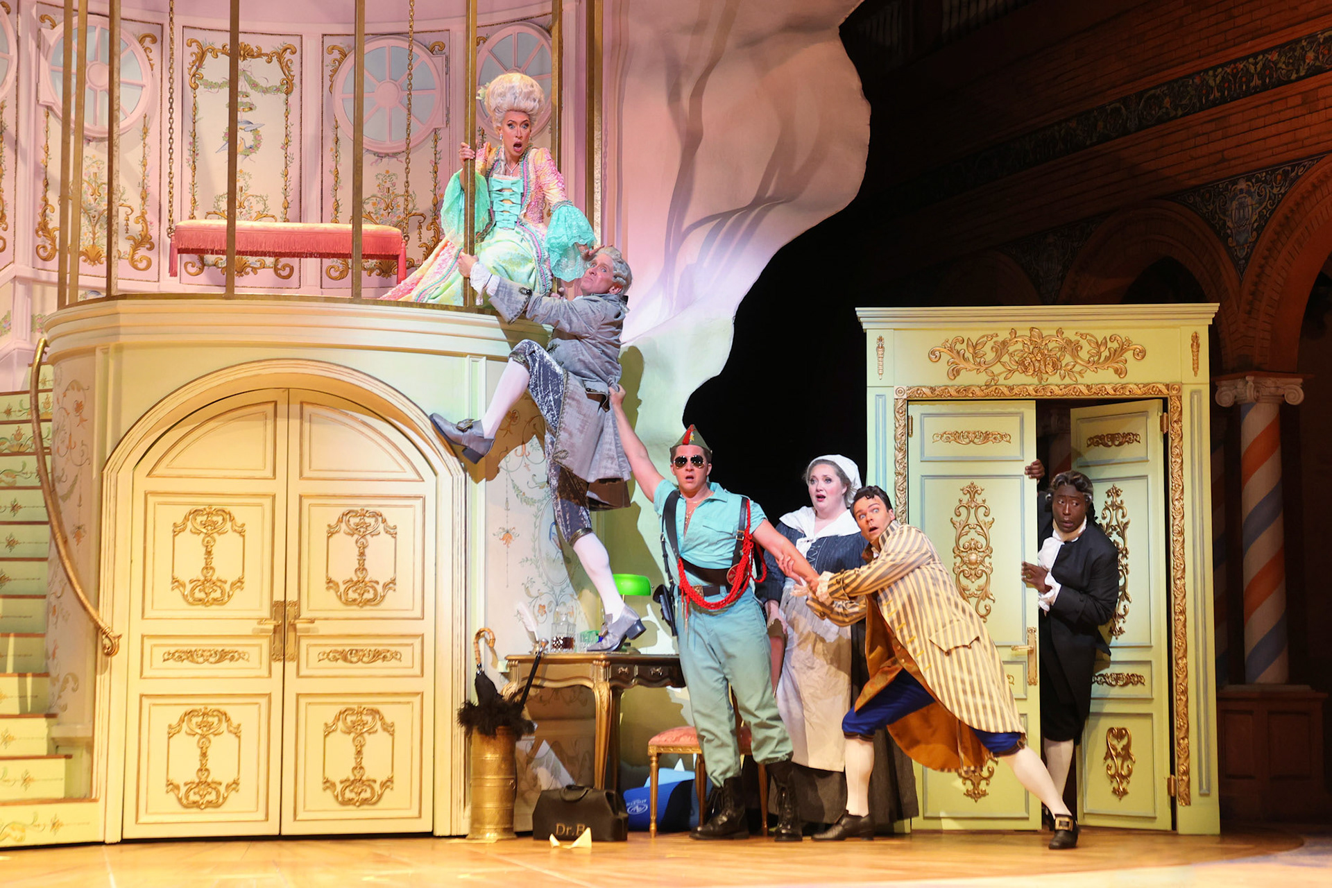 (from left to right) Rosina in her room accompanies by Dr. Bartolo, Count Almaviva, Berta, Figaro, and Don Basilio