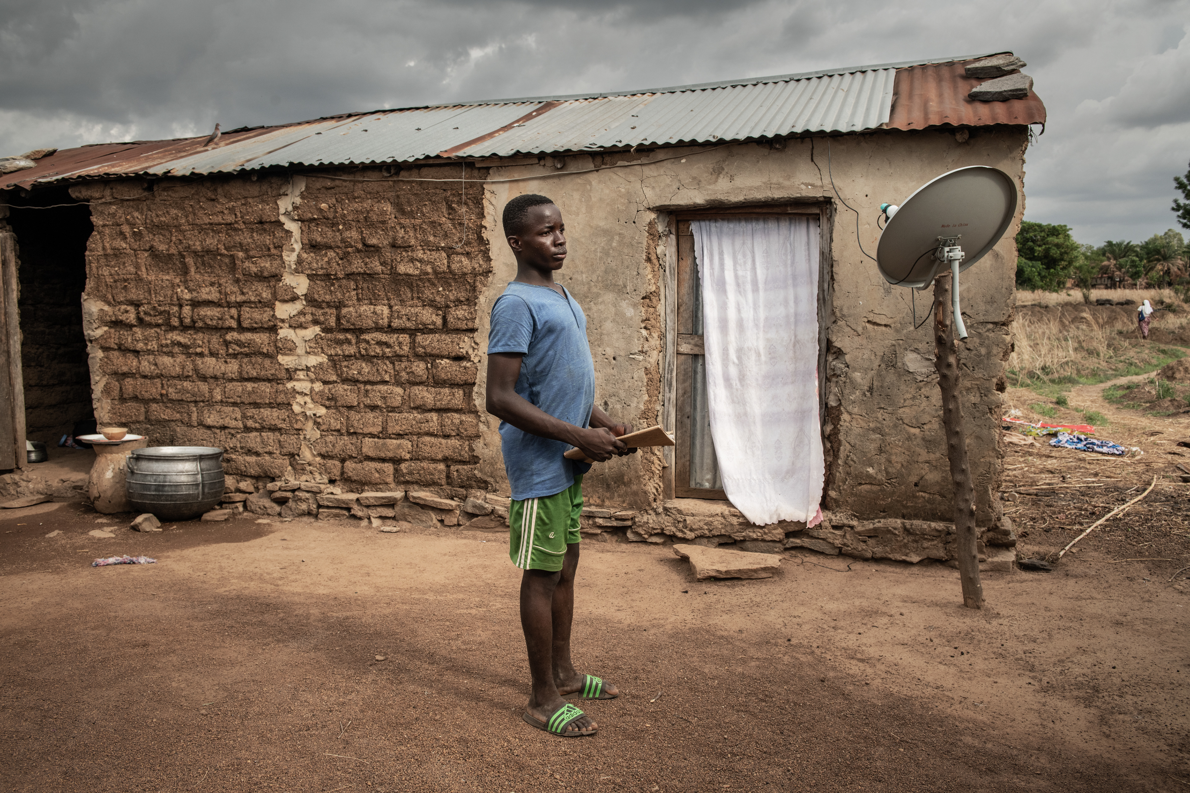A high school student in front of his home in Pagouda, Togo 2023