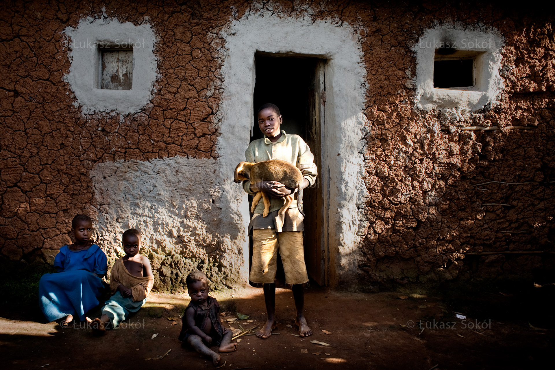 Eric Irakoze, aged 14, a 6th grade student of primary school. His father died, he lives with his mother and 2 brothers. After school he fetches water and helps at home. He bought the dog (it is a rarity in Rwanda) for 500 francs (approx. $1). It is the most important, because it keeps an eye on his house. When he grows up, he wants to become a bishop. His dream is to have clothes for school and shoes. Karama, Rwanda, 2010