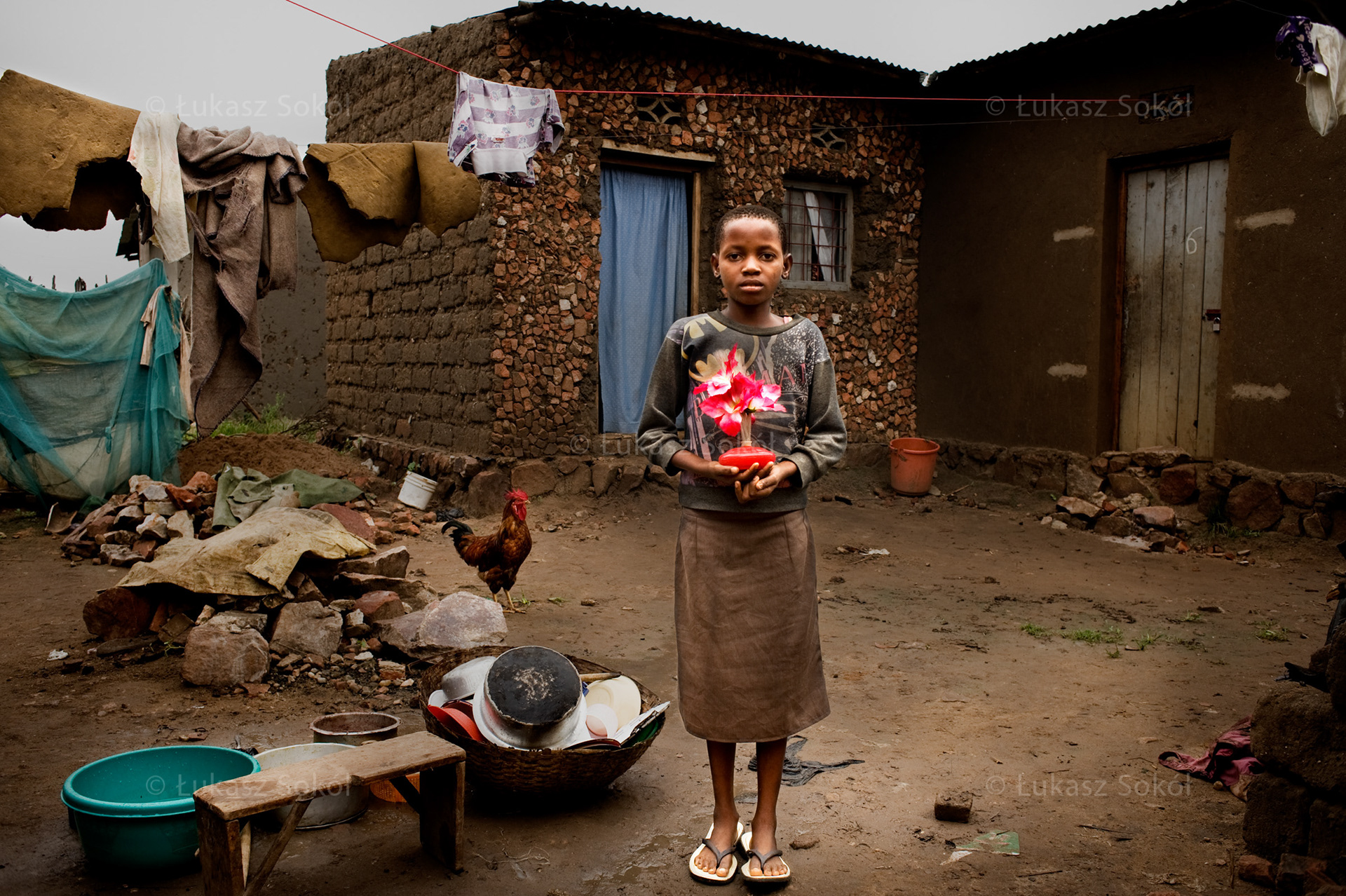 Joseline Nohimirimana, aged 12, a 3rd grade student of primary school. She lives with her parents and 4 siblings. After school she sweeps the floor, helps with washing and washes up after meals. She plays when she has enough time. She got the lamp from her father, it is shaped like flowers. She likes when it is on, because it gives nice colours. When she grows up, she wants to be a doctor. Bujumbura, Burundi, 2010