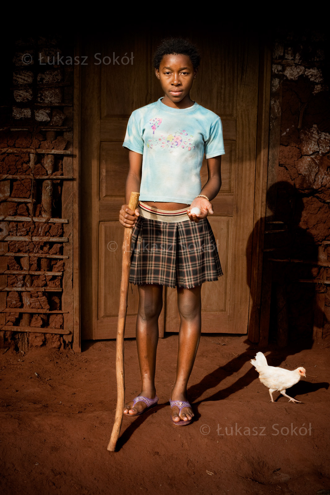 Floriane Metenla, aged 12, she has a brother and 2 sisters, her father is dead, she lives with her mother. After school she prepares meals, most often kuskus from manioc with leaves. She can make kuskus only by means of the stick, which she has cut by herself in the forest. She wants to be a doctor. In her hand she is holding an egg, which she is going to cook and eat in a moment. Ouama, Cameroon, 2009