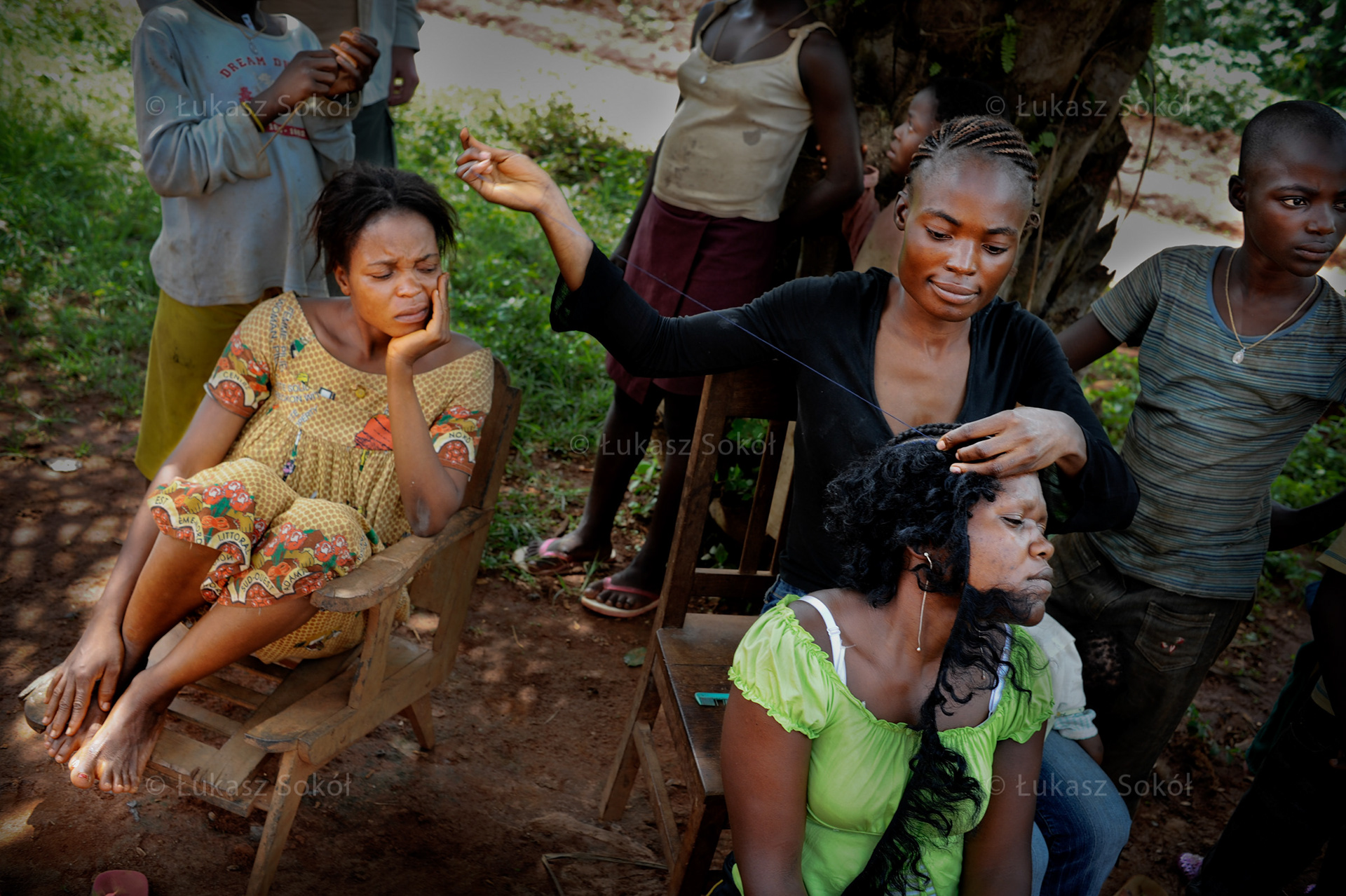 Women from the village of Essiengbot are combing their hair. In Cameroon women work harder than men. They cultivate the land, they carry wood and water and they look after the house. In fact, they do not have time for themselves, it happens that they come back to work on the fields right after the labour. They hardly ever find time for little pleasures such as a bath or other women’s company.  Essiengbot, Cameroon, 2009