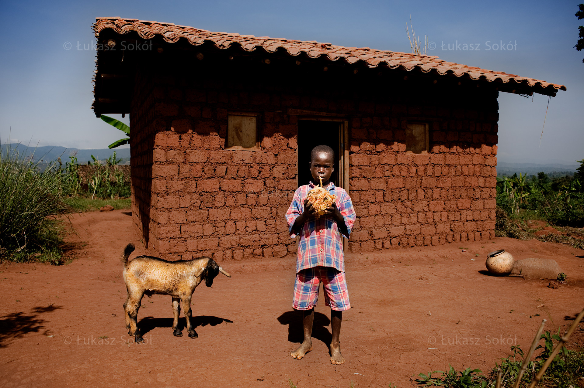 Gedeo Nigarimana, aged 11, a 4th grade student of primary school. He lives only with his mother, his father was killed during the war, their house wad damaged in revenge. For some time they lived with their mother’s brother, but recently they have built a new house thanks to additional help of Polish adoptive parents ($400). After school he fetches water, helps with cooking, puts wood in the fire. He also looks after 3 goats that belong to his neighbours. In return, they have manure which they use in the field. When he has enough time, he plays with the ball he made himself from old bags tied with a string. He likes the ball, because he and his friends have something to play with. He wants to become a priest. Buraniro, Burundi, 2010