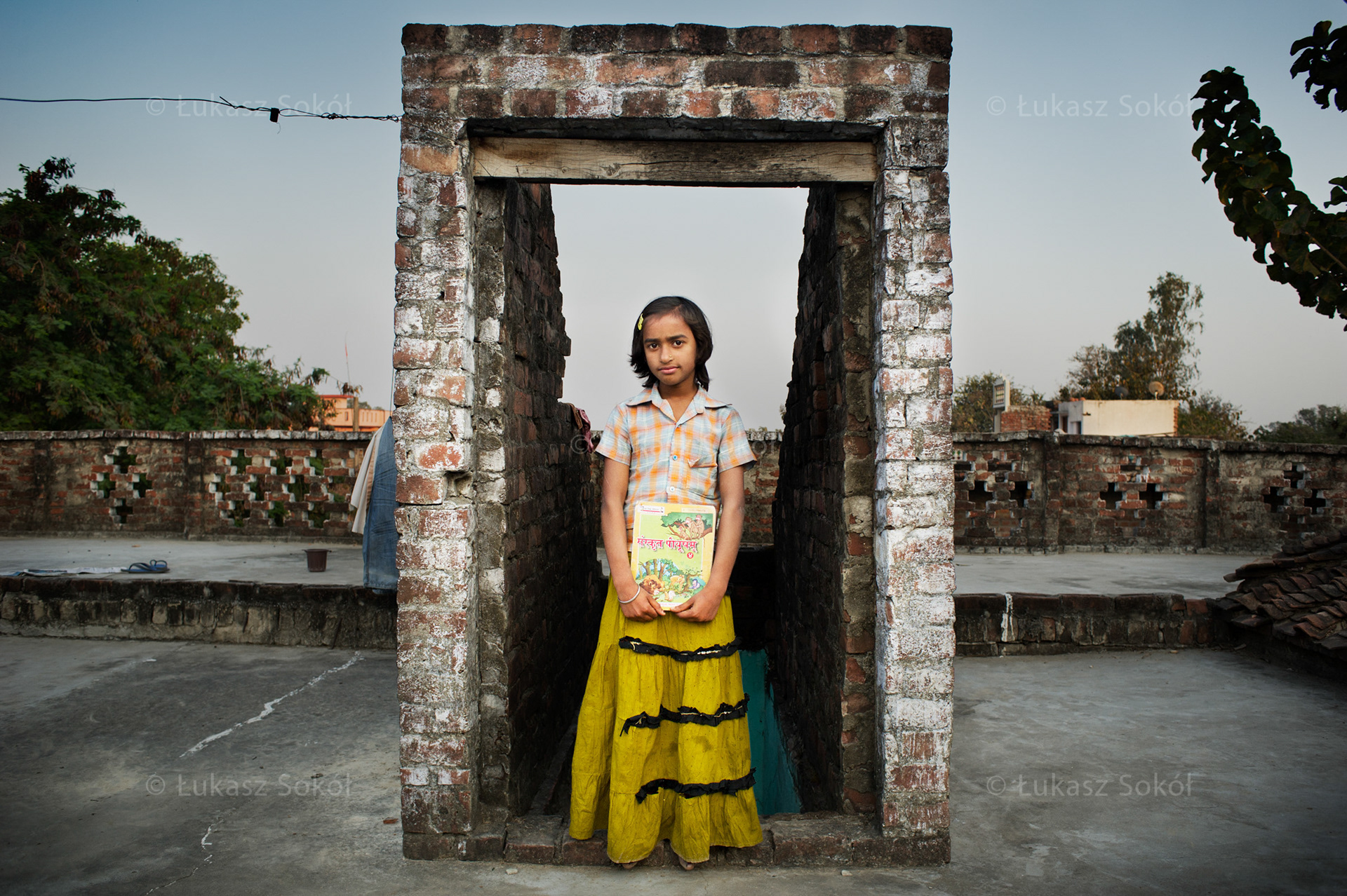Achal Pandey, 9 years old. She has a brother. She bought the Sanskrit book at the market. Sanskrit is her favourite subject at school. She would like to teach this language in future. In the morning she goes to school, then she helps her mother doing housework such as cleaning and cooking. Then she plays with children. Kakathi, India, 2012