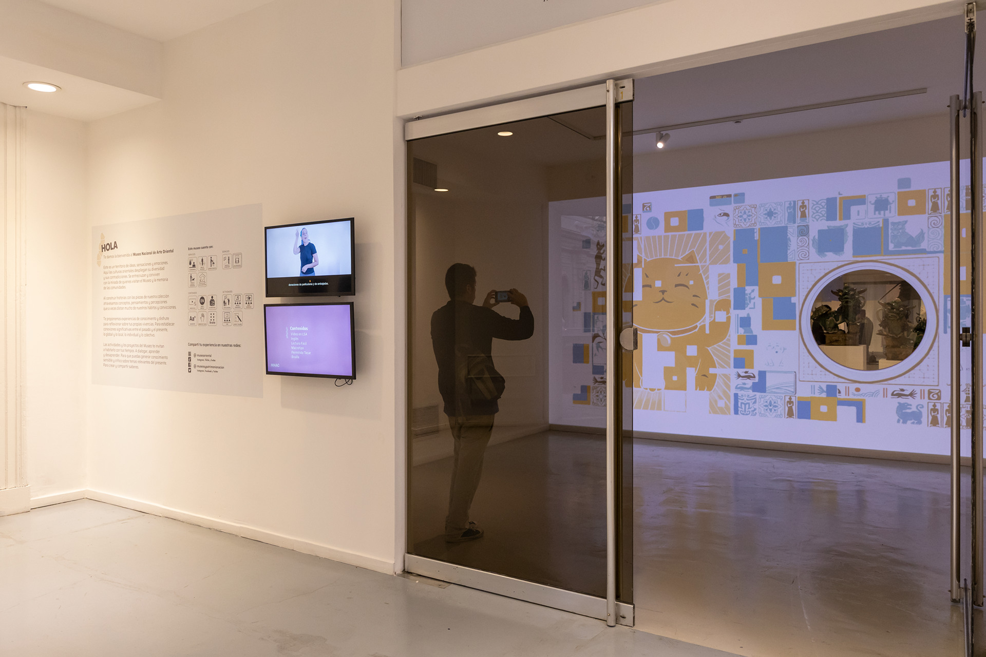 Vista desde el hall del Mapping que recibe a lxs visitantes. Vista de la entrada desde el hall, texto de bienvenida e información en código accesible, pictogramas y video en LSA. Foto: @mariana.poggio