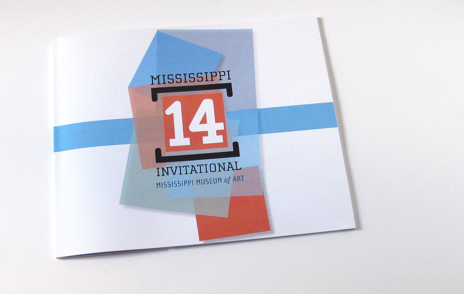 Exhibition catalogue with colored squares layered to make the shape of Mississippi on a white surface.