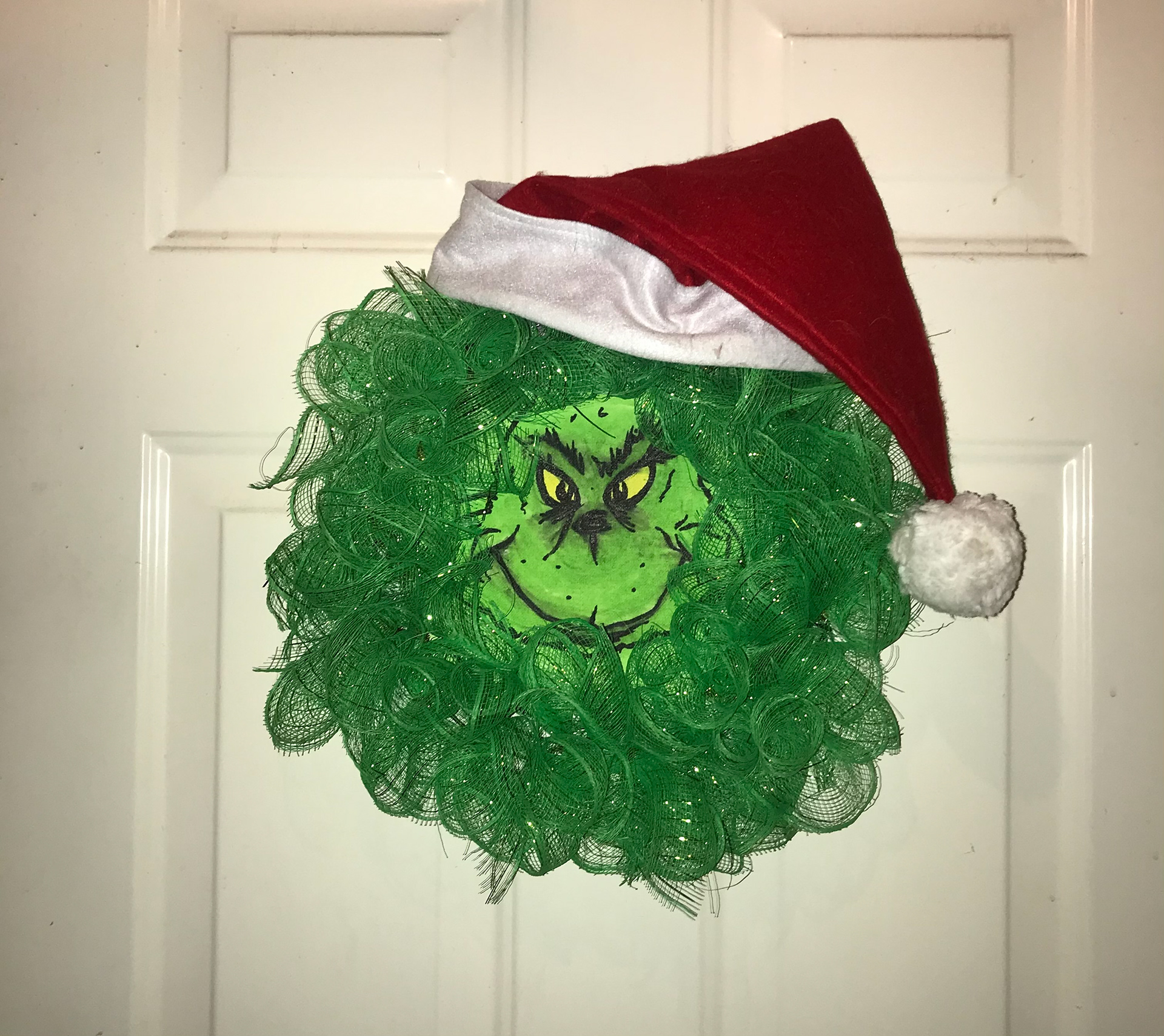 Friend-built holiday wreath with Grinch canvas.
