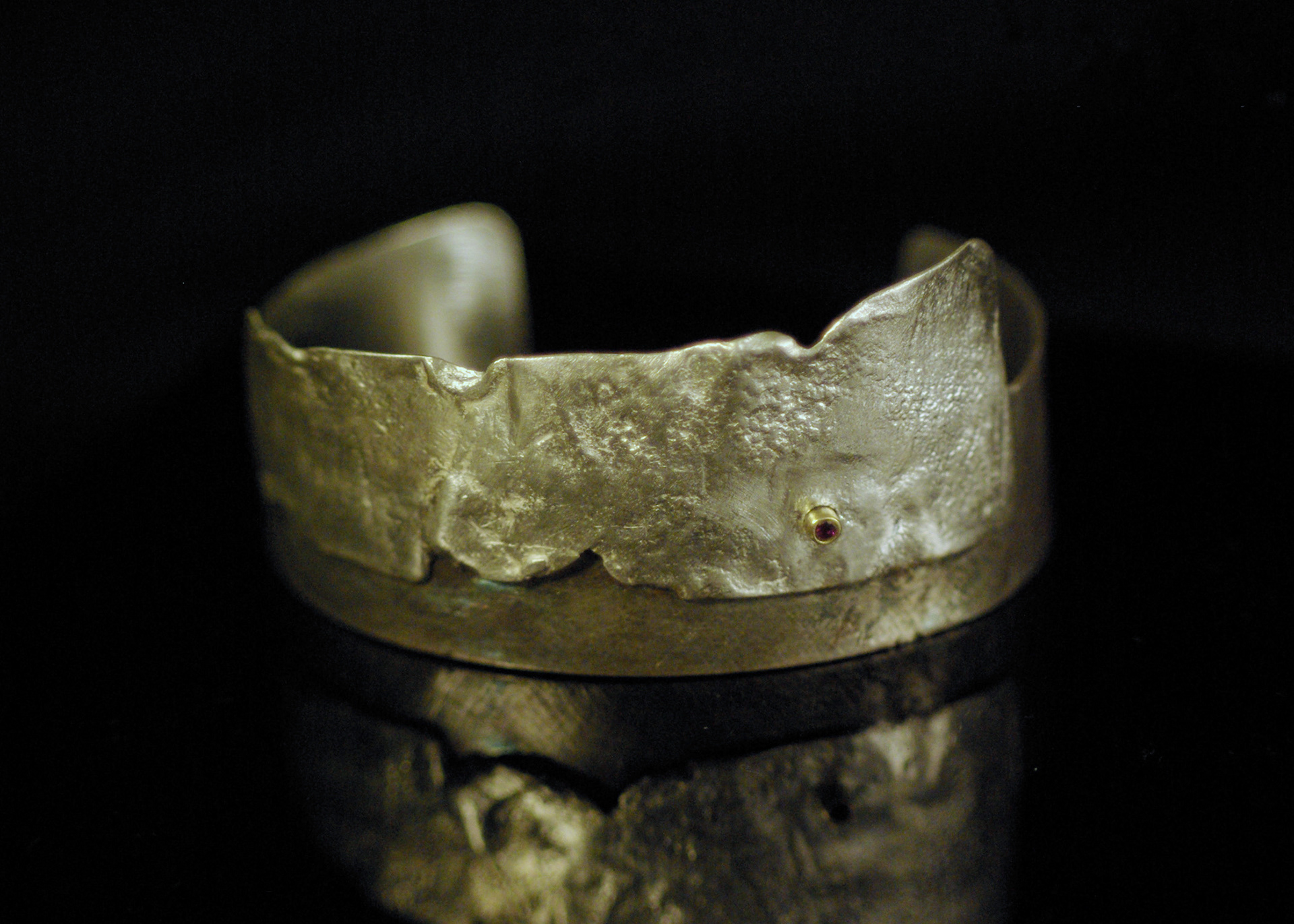 sterling silver cuff, oxidized overlaid with reticulated silver, ruby in 14Ky gold