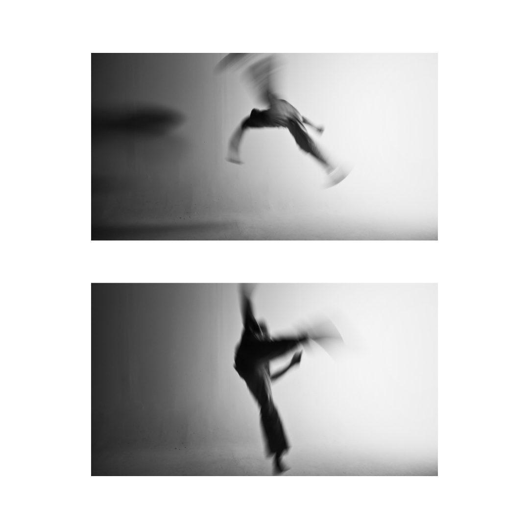 Image of masked model in white jeans finishing an aerial kick with motion blur and in black and white.