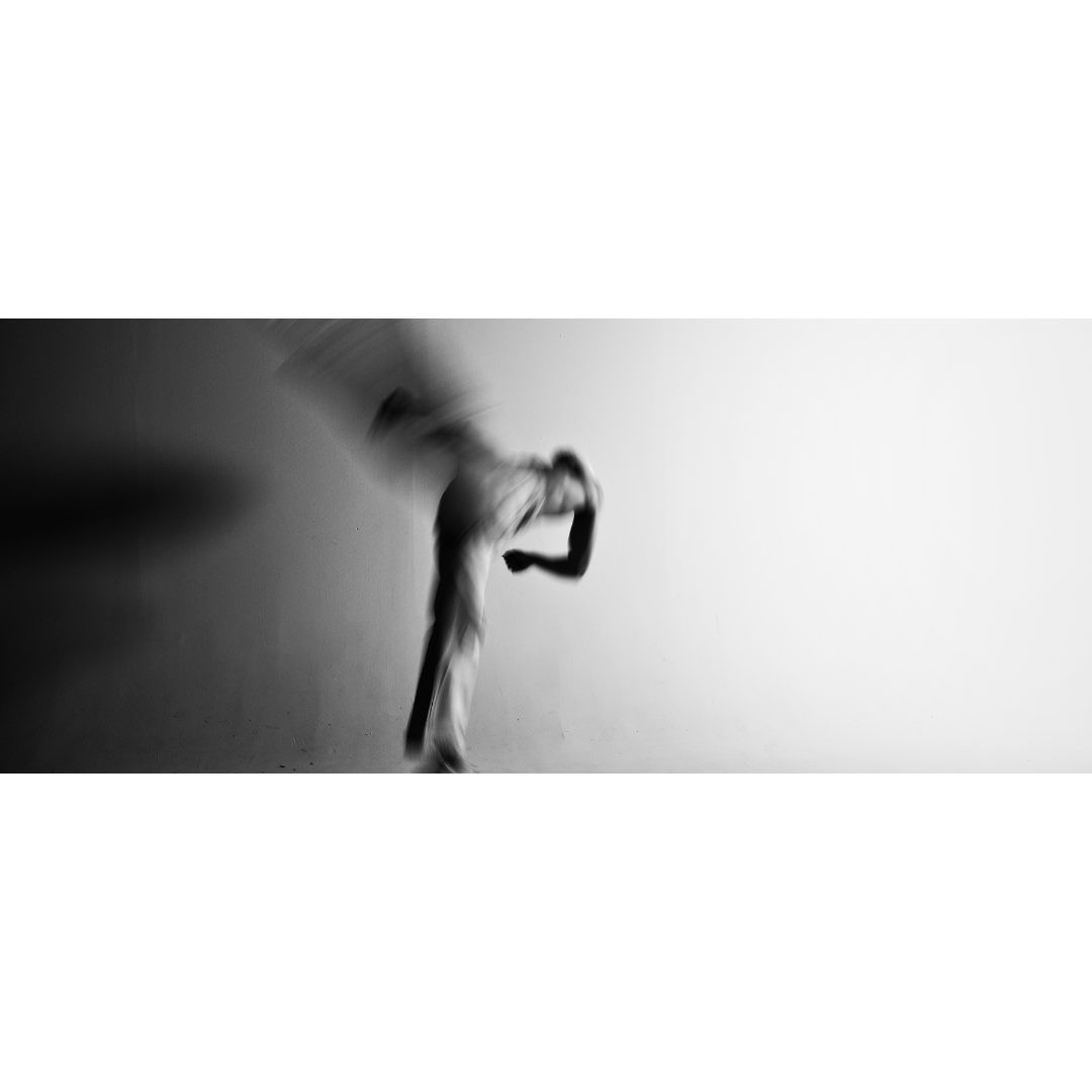 Wide format black and white motion blur photograph of a figure inthe midst of an aerial kick, body dissolving into movement, The Flying Crane, MINUSELEVEN AUDIOVISUAL
