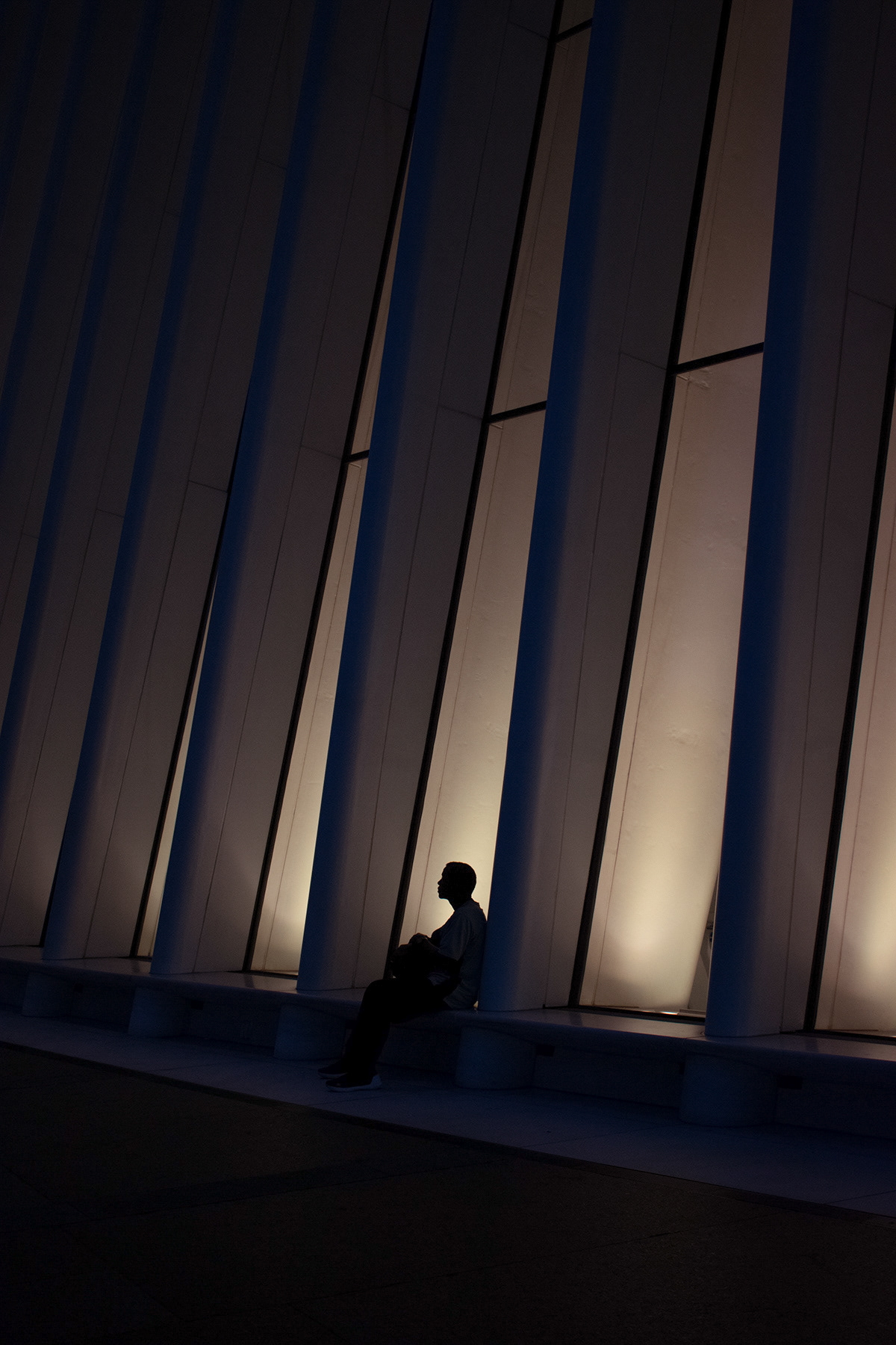Silhouetted man sits outside the Oculus World Trade Center Transportation Hub
