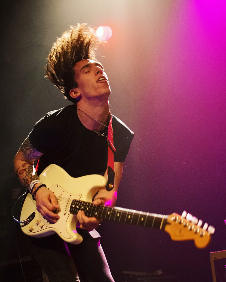Guitarist riffs his instrument while head-banging