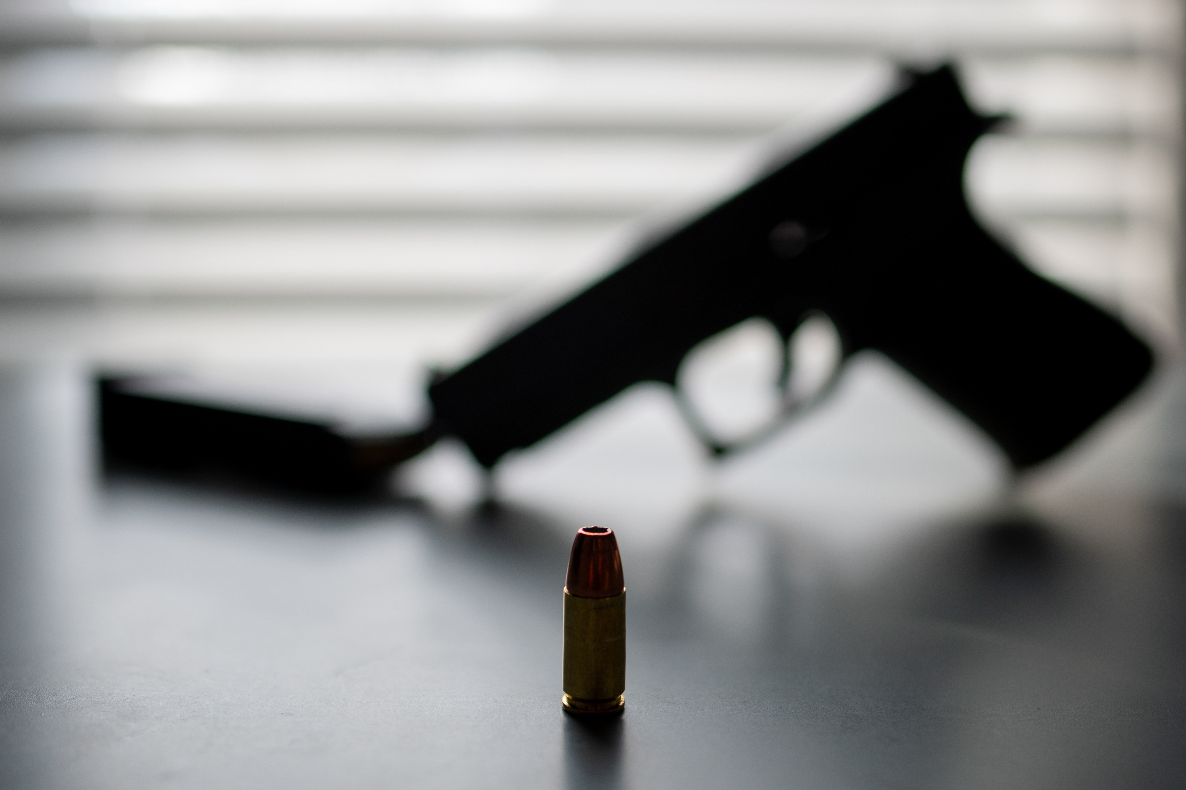 A Silhouette of a handgun, 9mm round, and a magazine