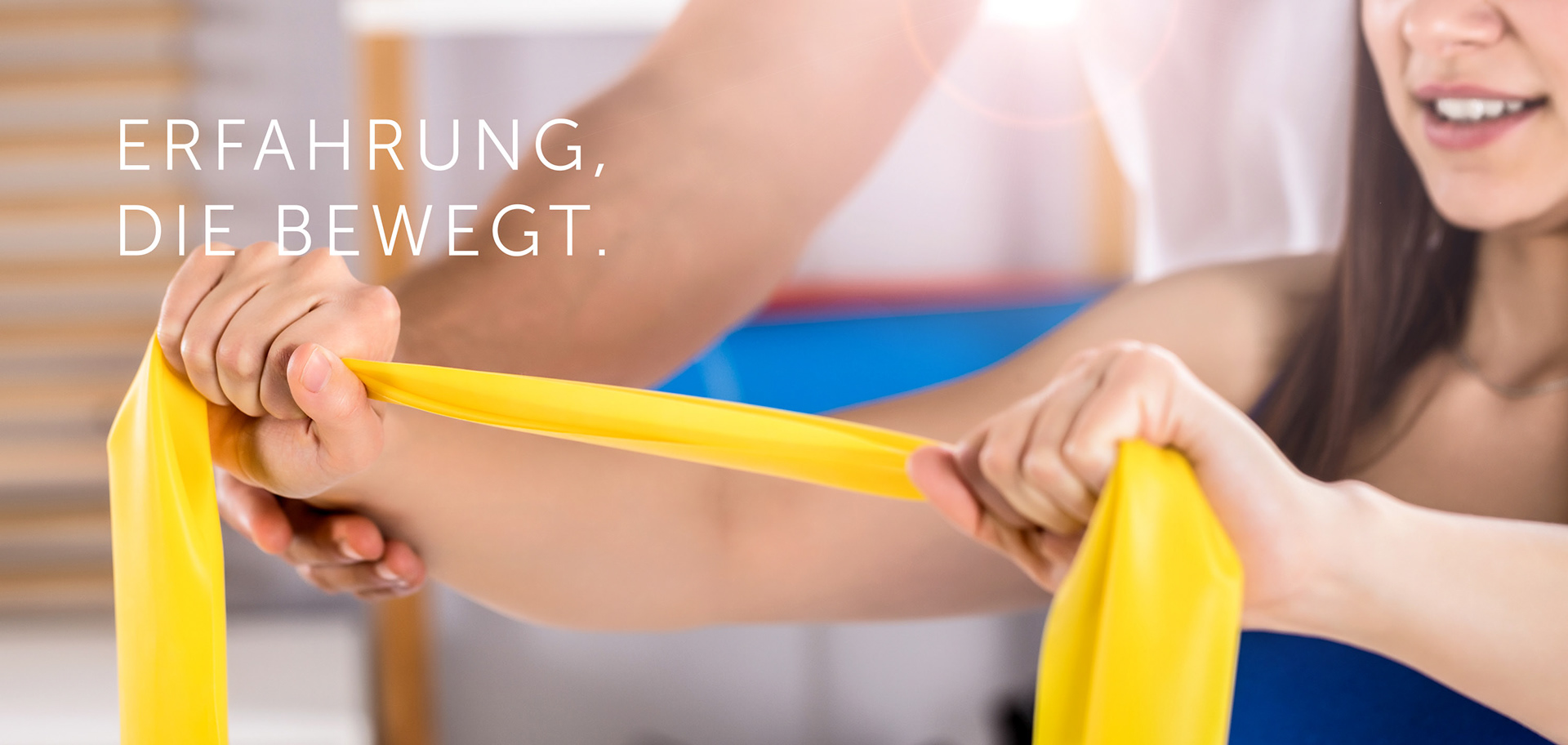 Physiotherapeutische Übung mit gelbem Theraband: Frau führt Widerstandsübung unter Anleitung eines Therapeuten durch – Symbolbild für Ergotherapie, Rehabilitation und individuelle Förderung motorischer Fähigkeiten.