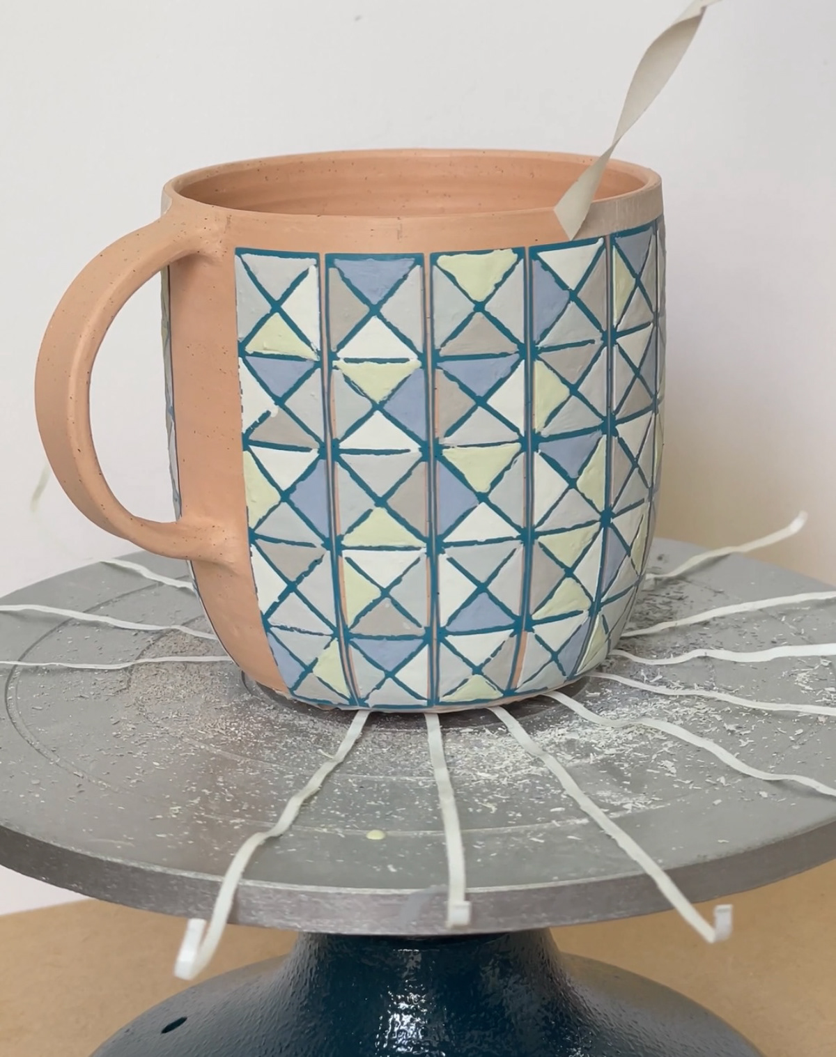 Removing vinyl and tape resist from a mug after glazing