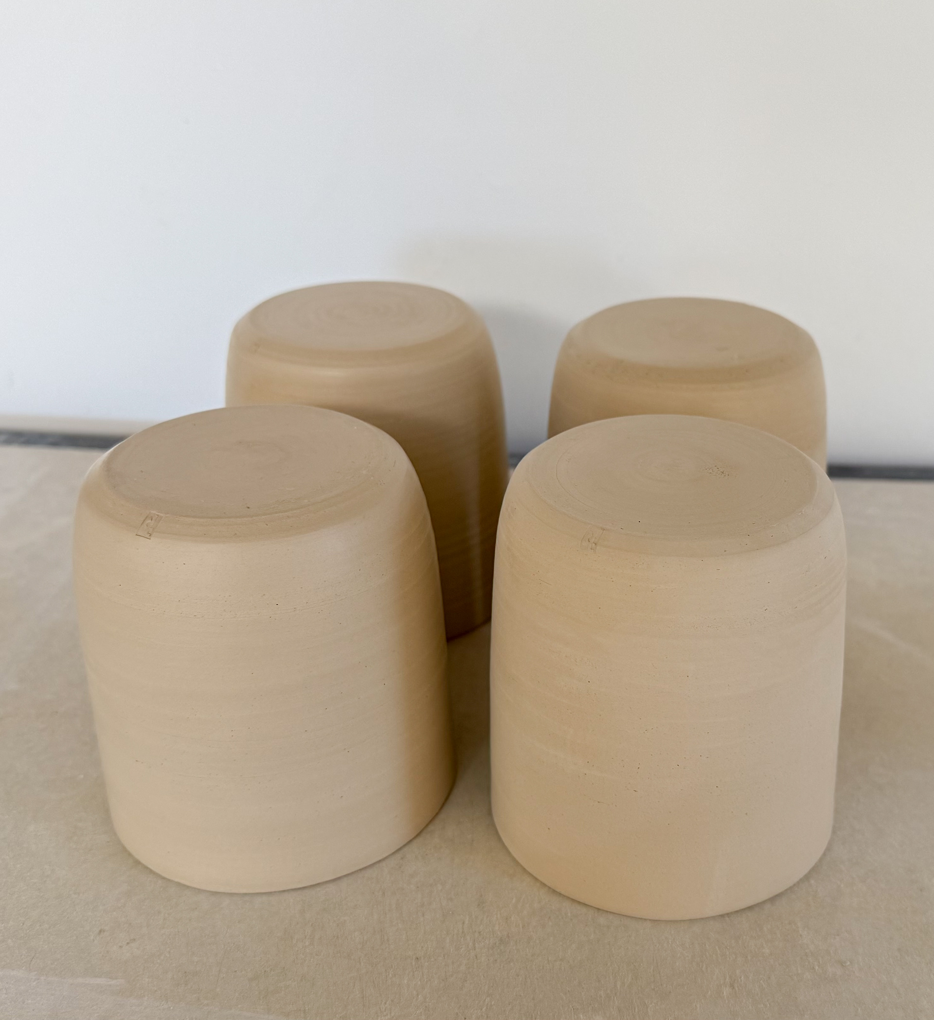 Four slip cast 8cm stoneware cups waiting to be fired