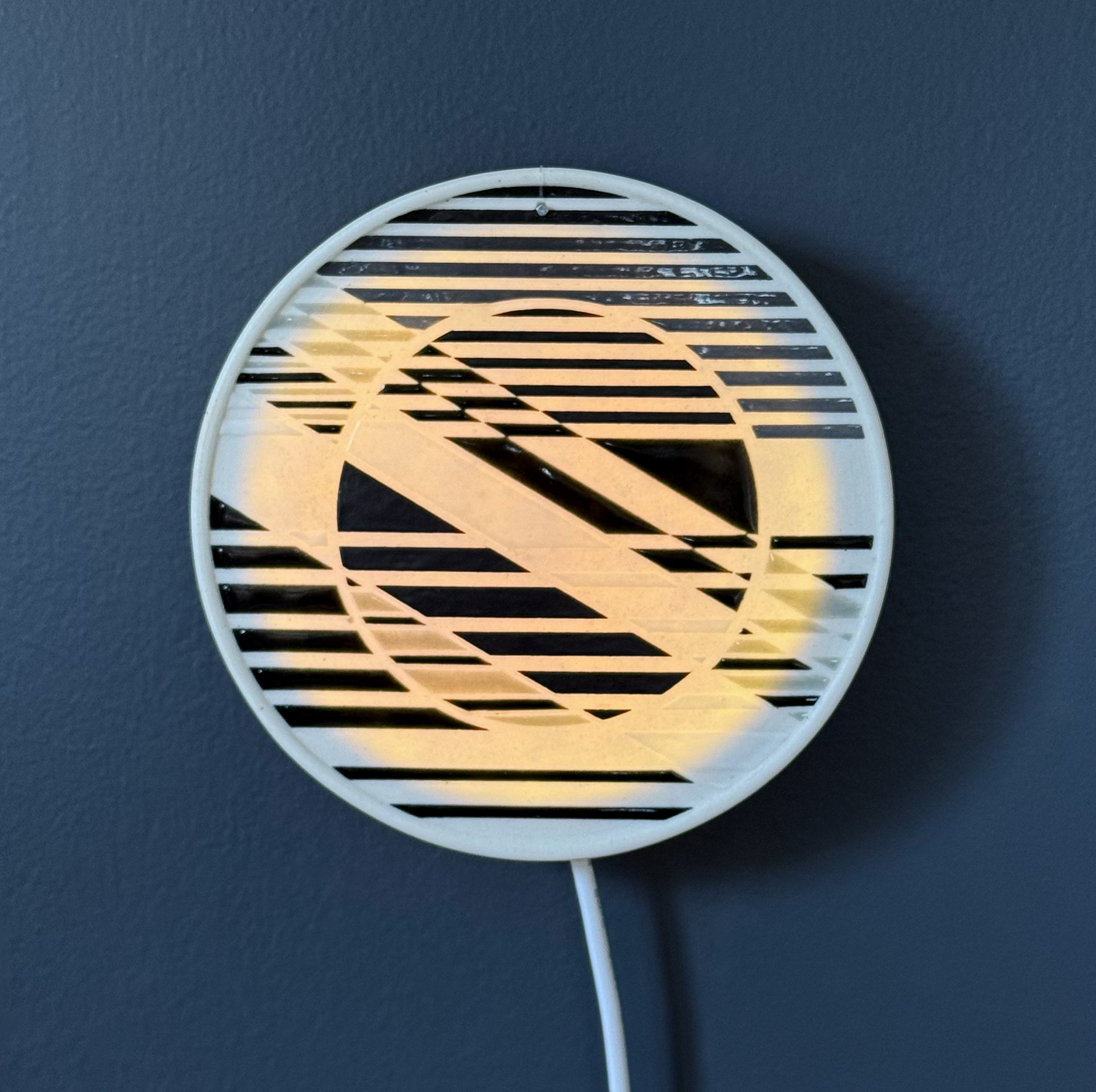 Lighting panel behind a porcelain wall tile. The LED light strip around the sides unfortunately isn't connected, if it was the full circle would be lit up.