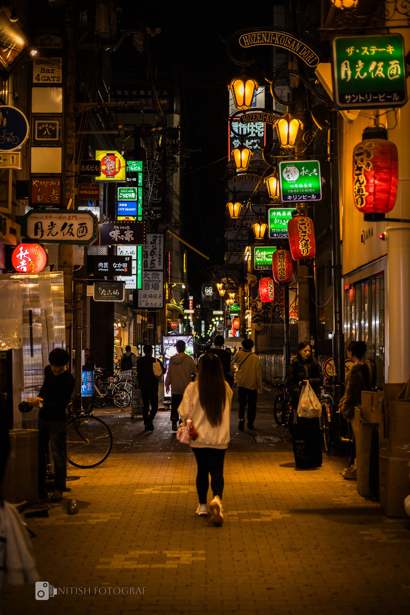 A solitary figure weaving through a vibrant cityscape lit by color and life