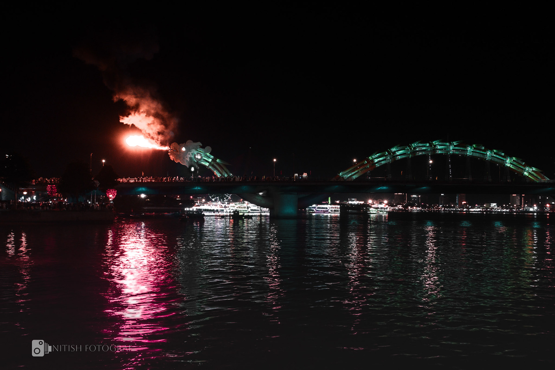 A city bridge glowing under the night sky its reflection dancing on the water