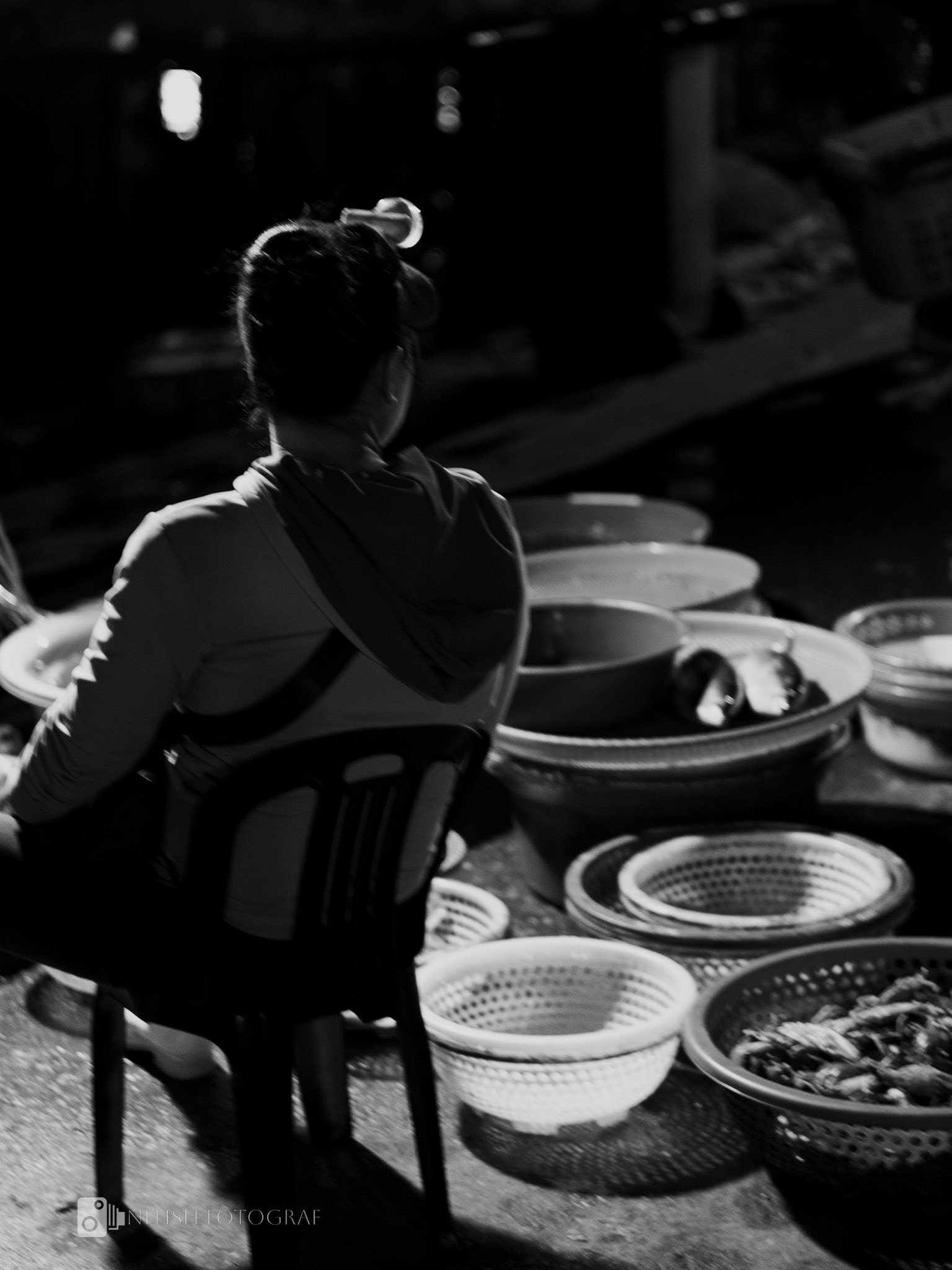 Reflections of routine – a vendor’s pause amidst the bustle of the market