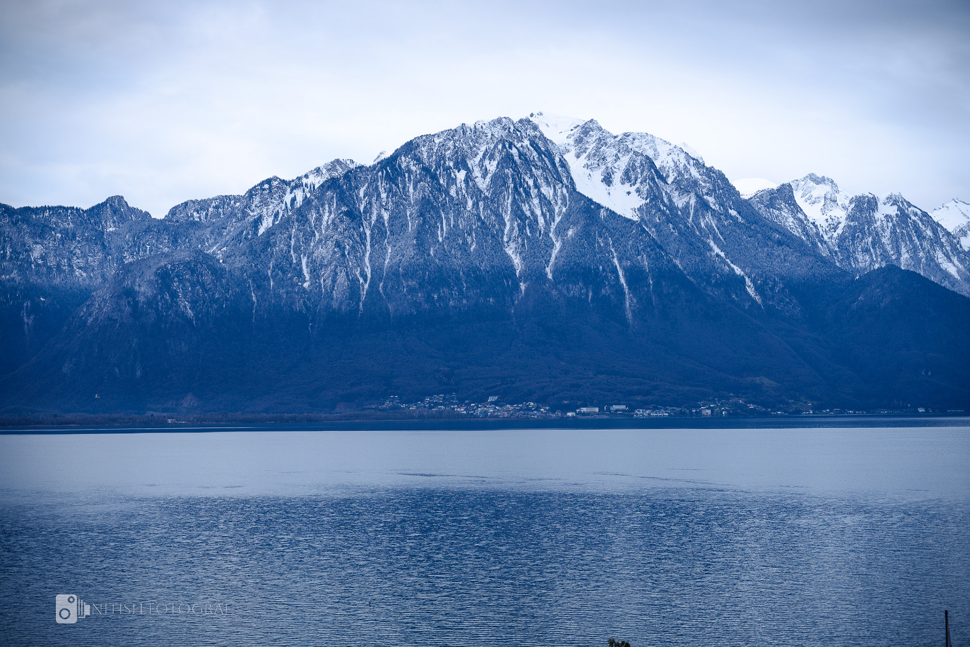 Towering peaks blanketed in snow standing strong against a piercing blue sky