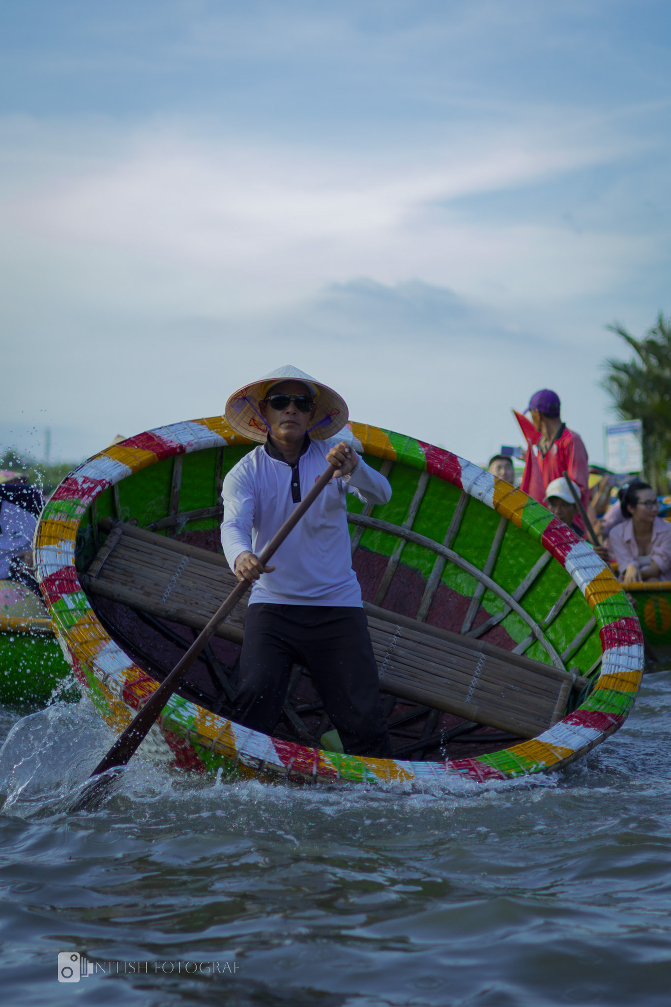 Navigating life’s waters – a fisherman paddles through vivid reflections.