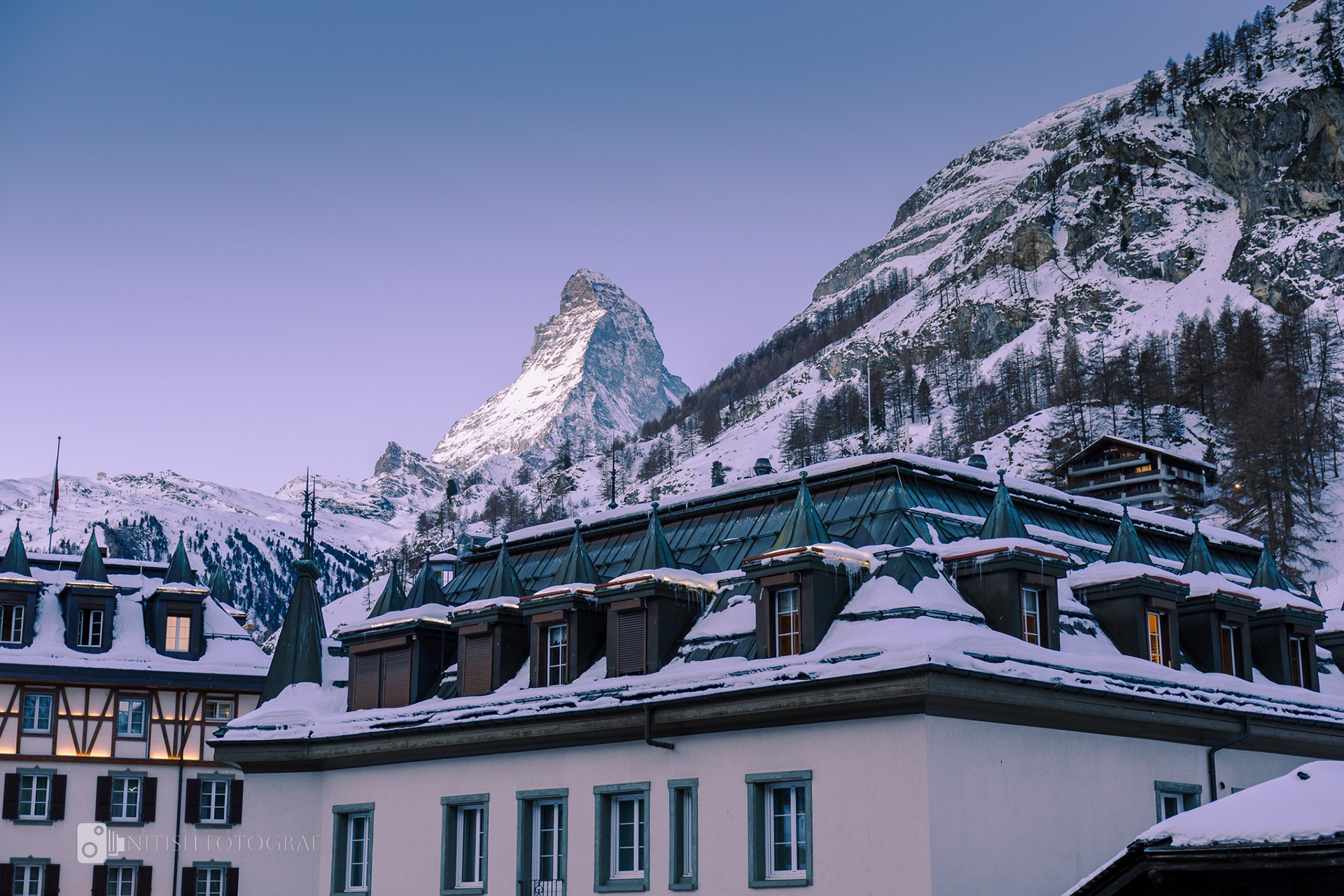 A cozy village nestled under snow-covered peaks exuding winter charm