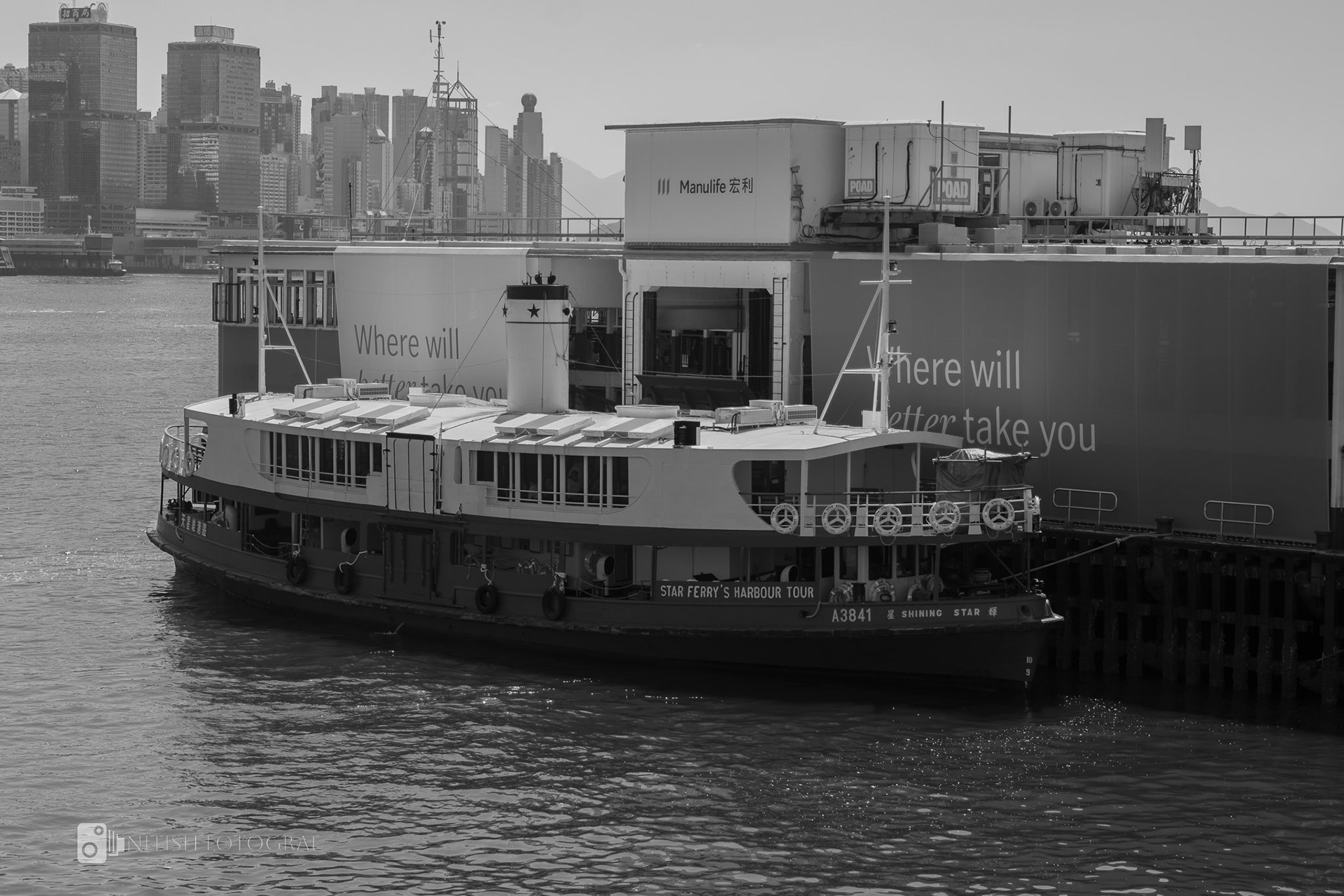A black-and-white capture of a ferry navigating through foggy waters