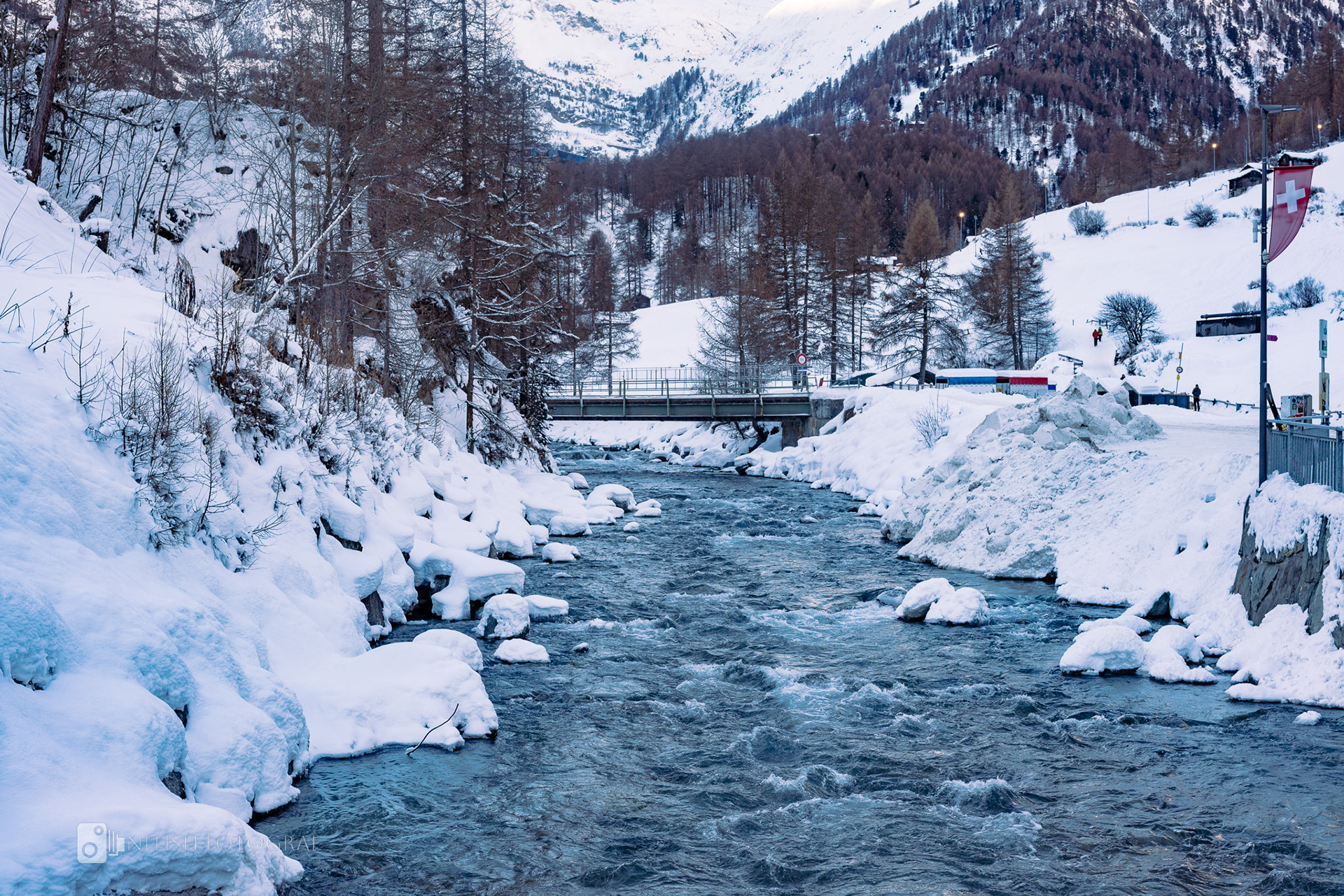 An icy river weaving through a snow-blanketed landscape