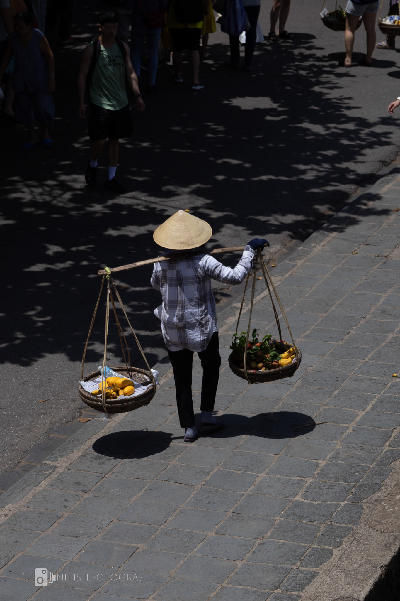 Balancing tradition and trade – a vendor on the move under the midday sun
